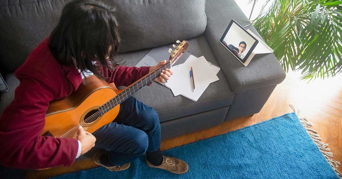 Man learning to play guitar online